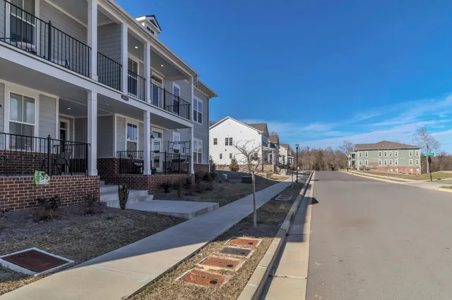 a city view with tall buildings and cars parked on road