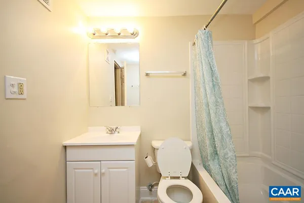 a bathroom with a sink a mirror a toilet and a shower