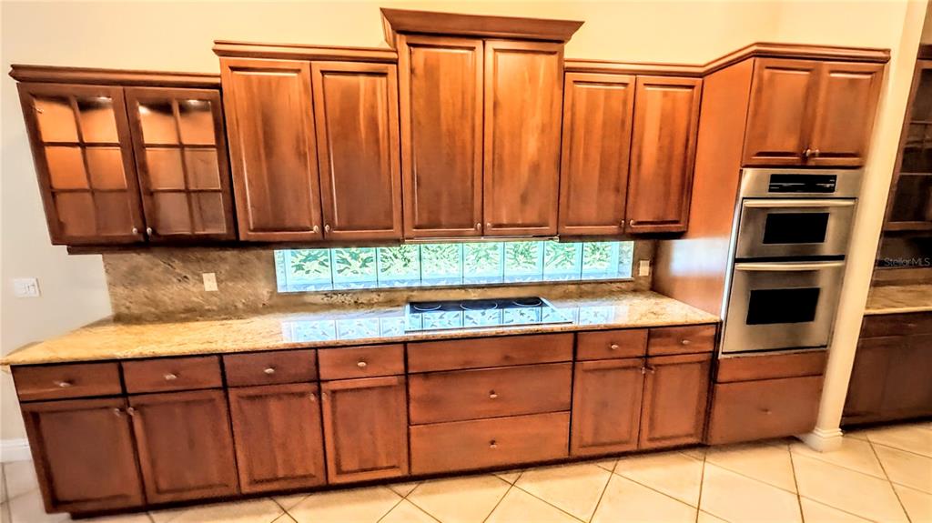 124 Turquoise Lane Osprey, FL 34229 - Photo 12 of 48 a kitchen with stainless steel appliances wooden cabinets a stove and a microwave