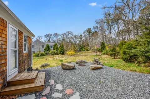 a view of a house with backyard and trees