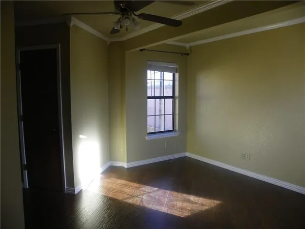 an empty room with a window and ceiling fan