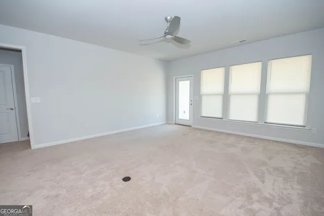 an empty room with a window and a ceiling fan