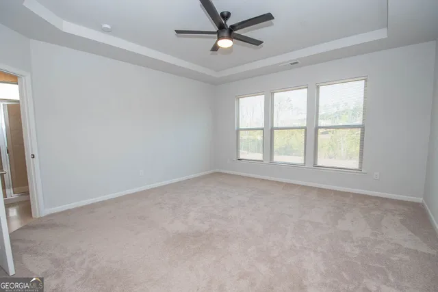 an empty room with a ceiling fan and window