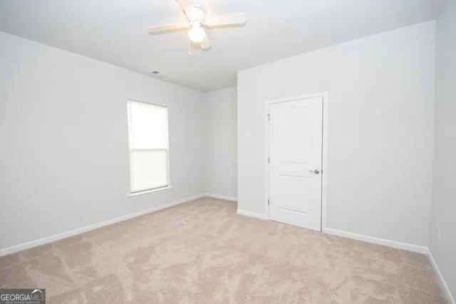 an empty room with a chandelier fan