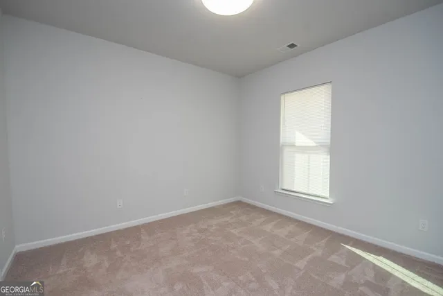 an empty room with closet and a bathroom
