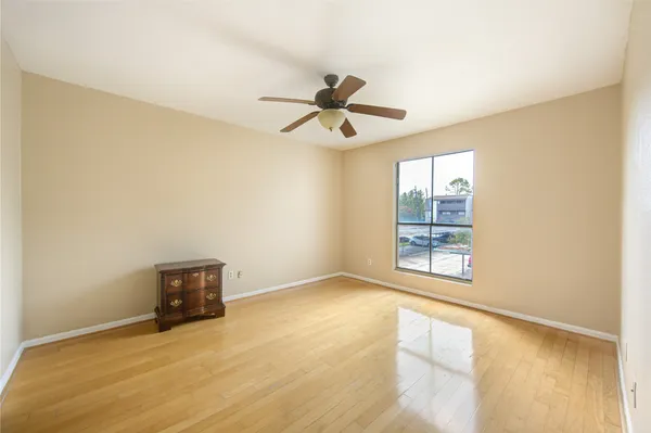 an empty room with windows and ceiling fan view