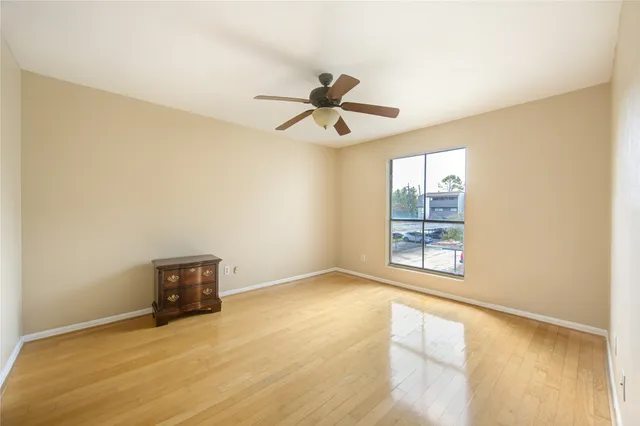 an empty room with windows and ceiling fan view