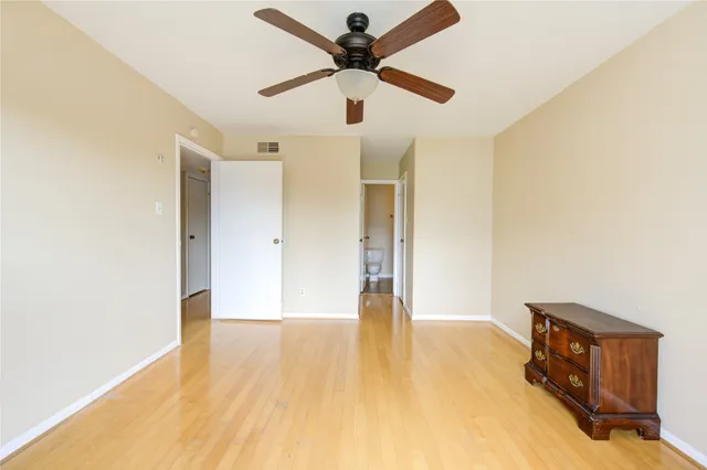 a view of an empty room with window and a ceiling fan