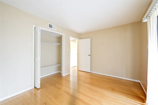 an empty room with wooden floor and closet