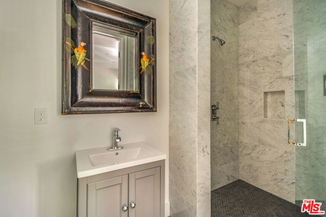 9669 Oak Pass Road Beverly Hills, CA 90210 - Photo 31 of 37 a bathroom with a sink and a mirror
