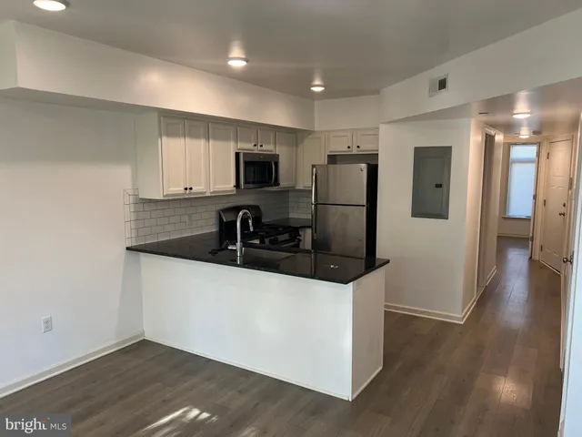 a kitchen with stainless steel appliances a refrigerator and a stove top oven