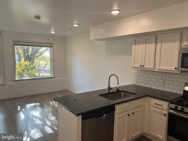 a kitchen with a sink cabinets and window