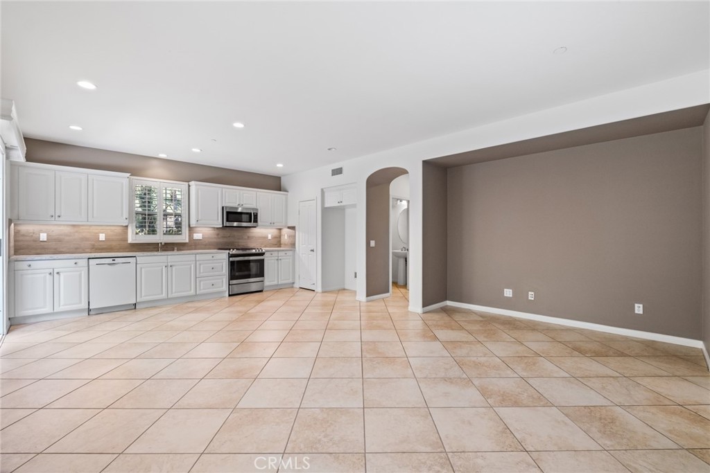 61 Bellwind Irvine, CA 92603 - Photo 5 of 22 a large white kitchen with a cabinetry and a sink