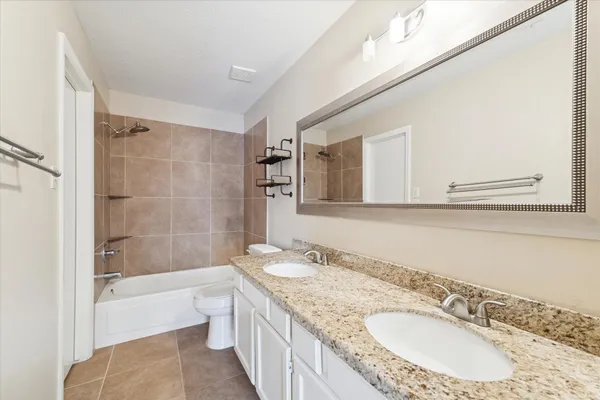 a bathroom with a granite countertop sink mirror bathtub and shower