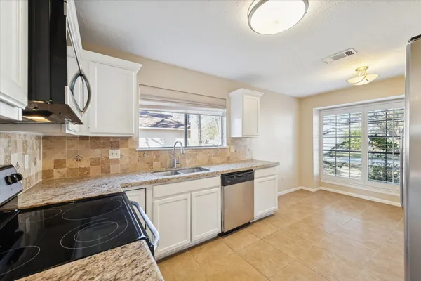 a kitchen with a sink stove and cabinets