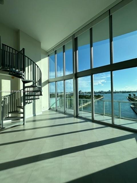 a view of staircase with a floor to ceiling window and a ceiling fan