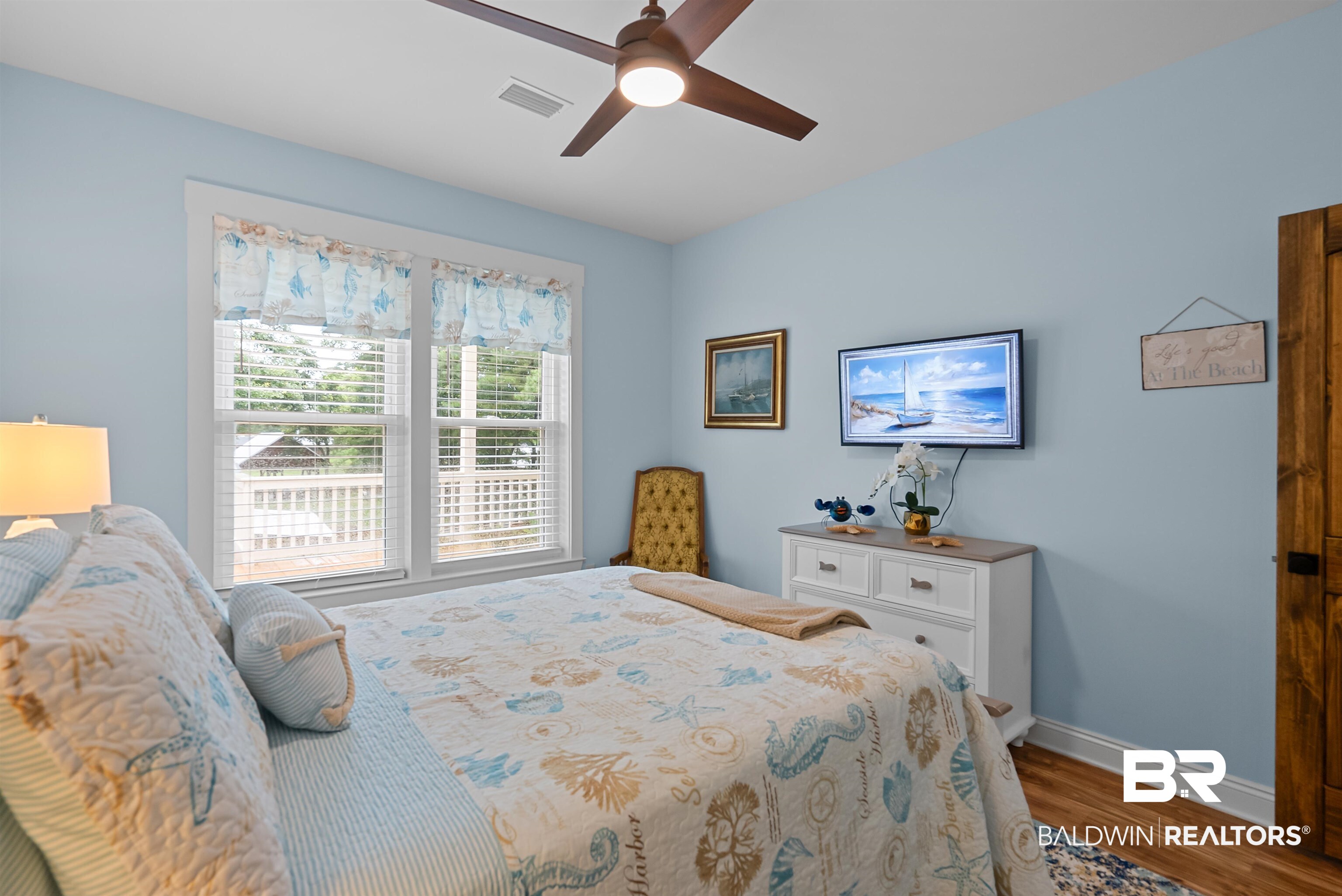 7266 Franklin Road Foley, AL 36535 - Photo 30 of 64 Room featuring two large windows with blinds, a ceiling fan with integrated lighting, wood-finish flooring, and a wall-mounted flat-screen television