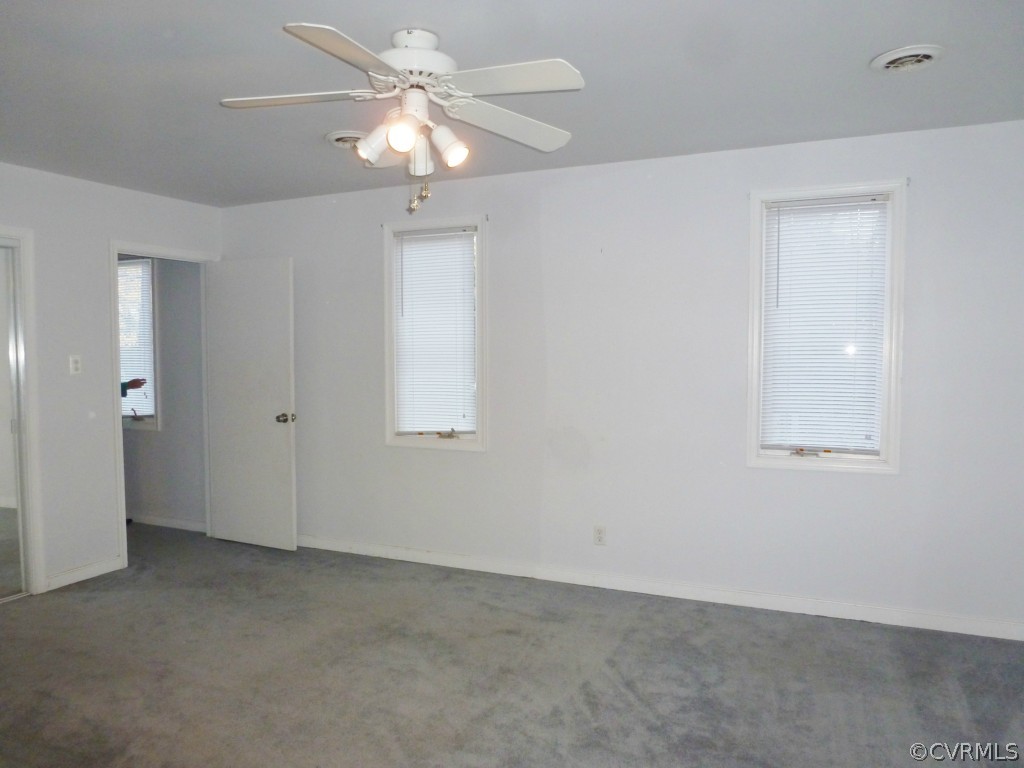 10424 Melissa Mill Road Chesterfield, VA 23236 - Photo 13 of 23 an empty room with a chandelier fan and windows
