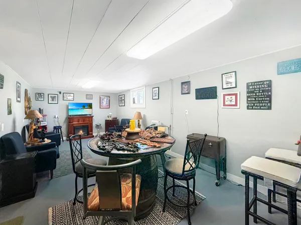 a living room with furniture and a dining table with bookshelf