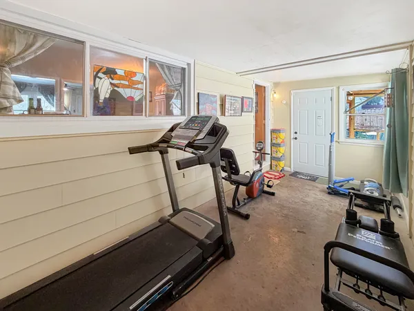 a room with gym equipment and wooden floor