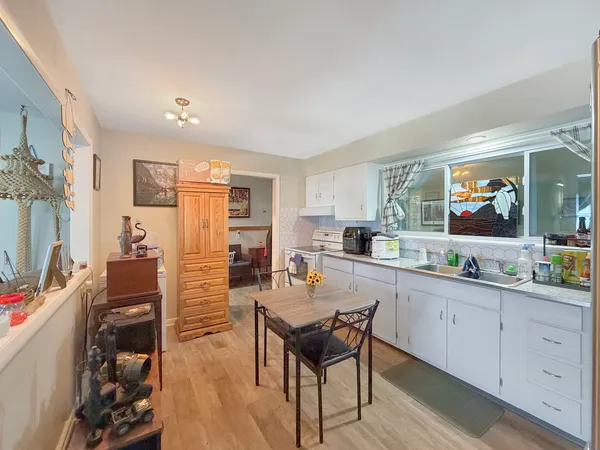 a kitchen with stainless steel appliances granite countertop a stove a sink a dining table and chairs