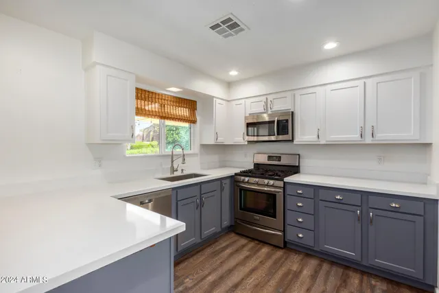 a kitchen with stainless steel appliances a refrigerator sink and microwave