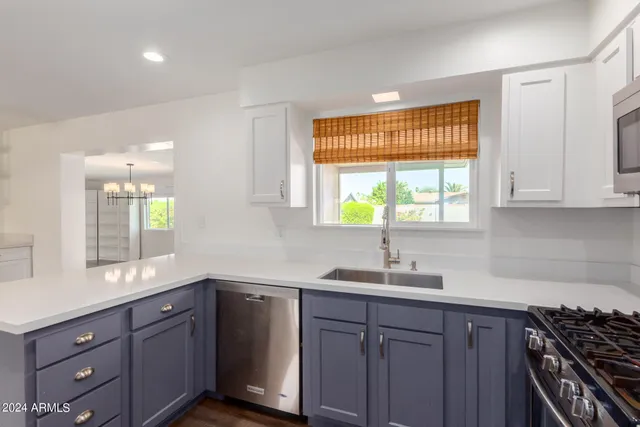 a kitchen with stainless steel appliances granite countertop a sink stove and microwave