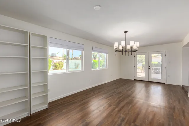 a view of a livingroom with wooden floor and a kitchen