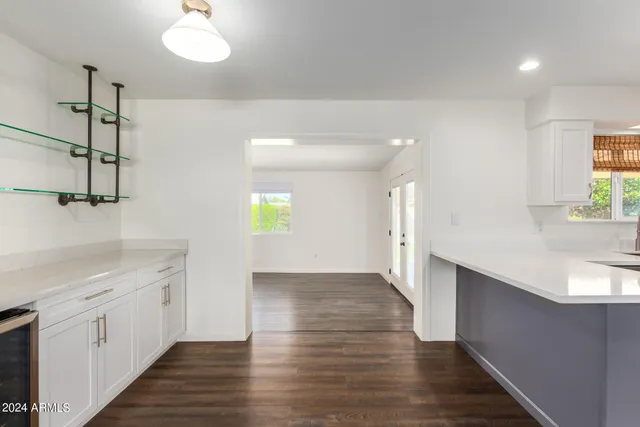 a large kitchen with a center island wooden floor and stainless steel appliances