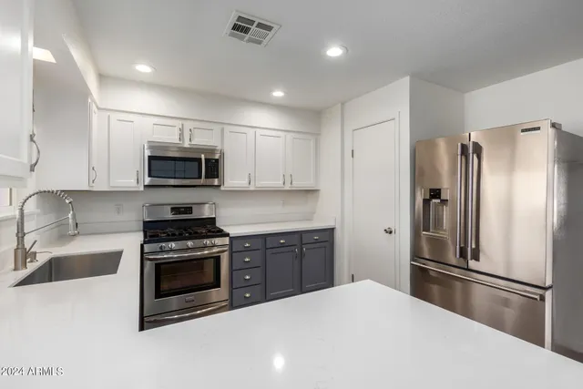 a kitchen with stainless steel appliances a refrigerator and a stove top oven