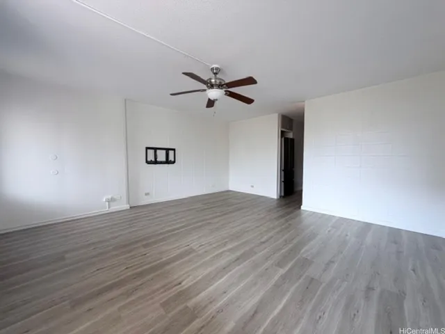 a view of a big room with wooden floor and a ceiling fan