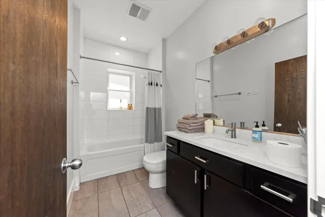 a bathroom with a granite countertop sink a toilet a mirror and shower