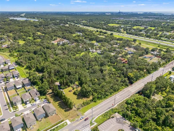 an aerial view of residential houses with outdoor space and trees