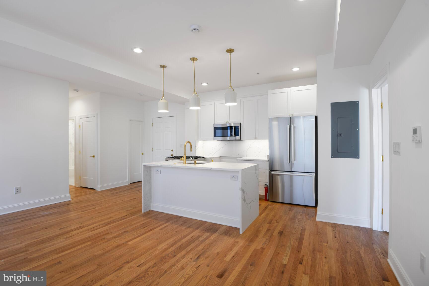 1351 Wisconsin Avenue Northwest, Unit 2B Washington, DC 20007 - Photo 1 of 20 a large kitchen with a wooden floor and a refrigerator