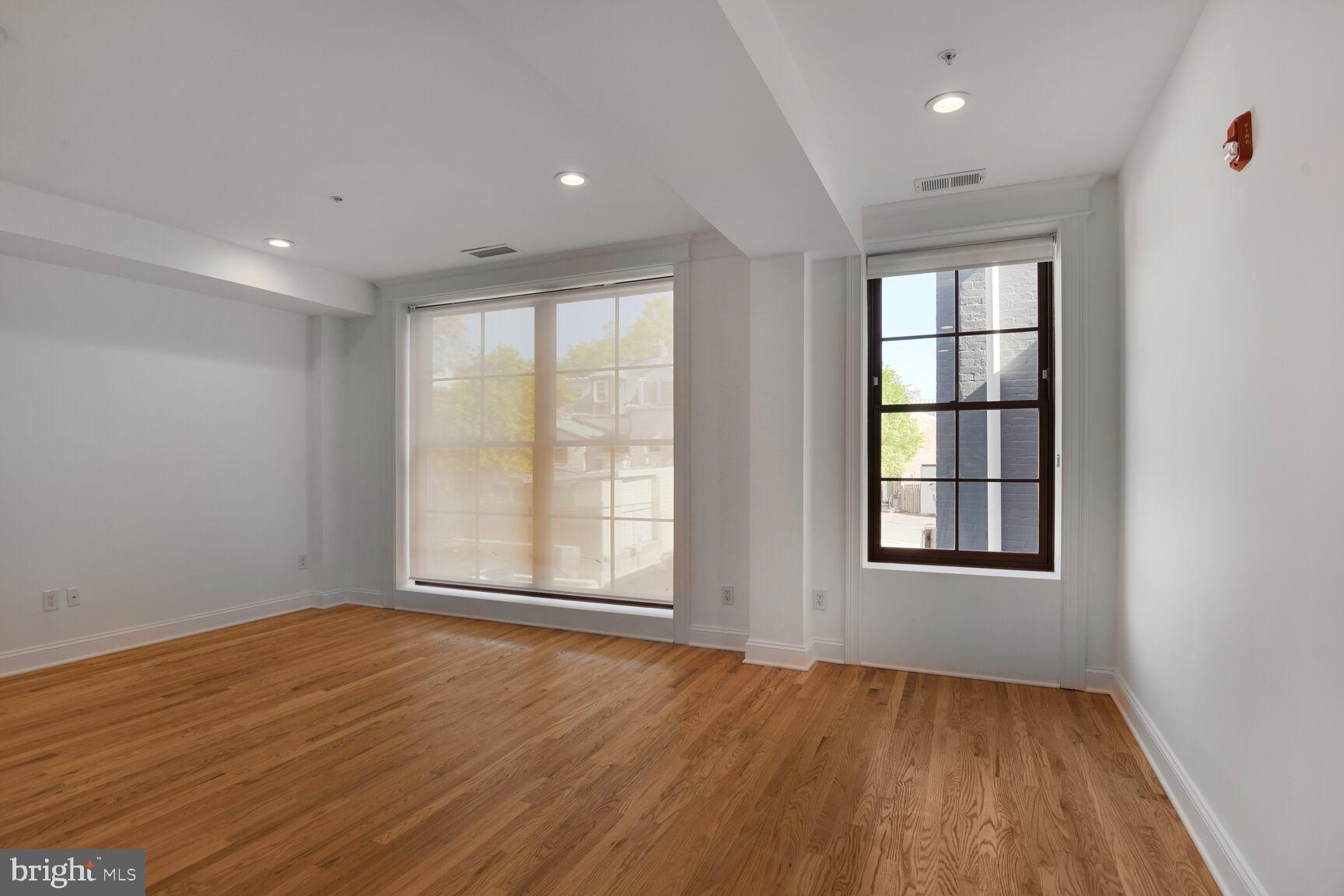 1351 Wisconsin Avenue Northwest, Unit 2B Washington, DC 20007 - Photo 14 of 20 an empty room with wooden floor and windows