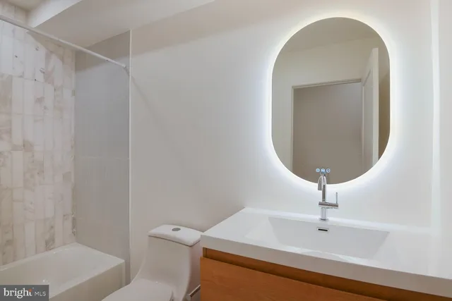 a bathroom with a toilet a sink and mirror