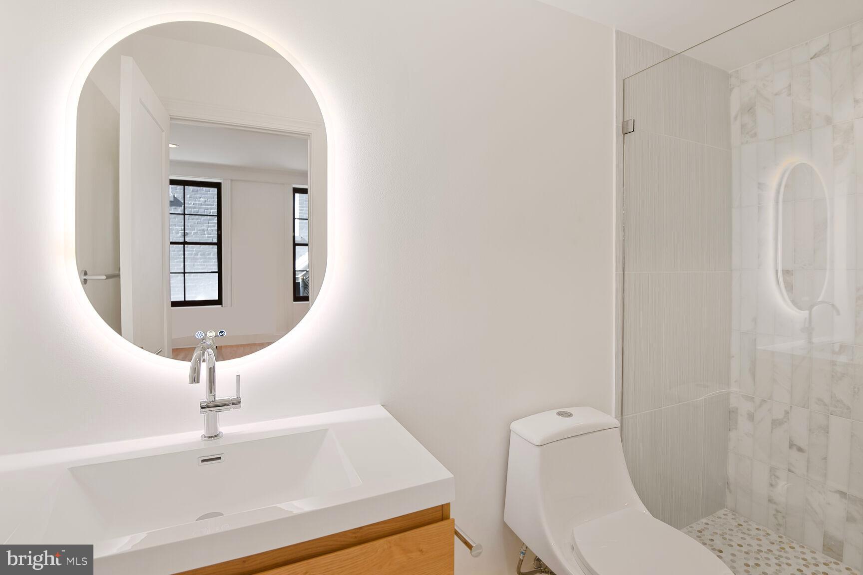 1351 Wisconsin Avenue Northwest, Unit 2B Washington, DC 20007 - Photo 17 of 20 a bathroom with a toilet a sink and mirror