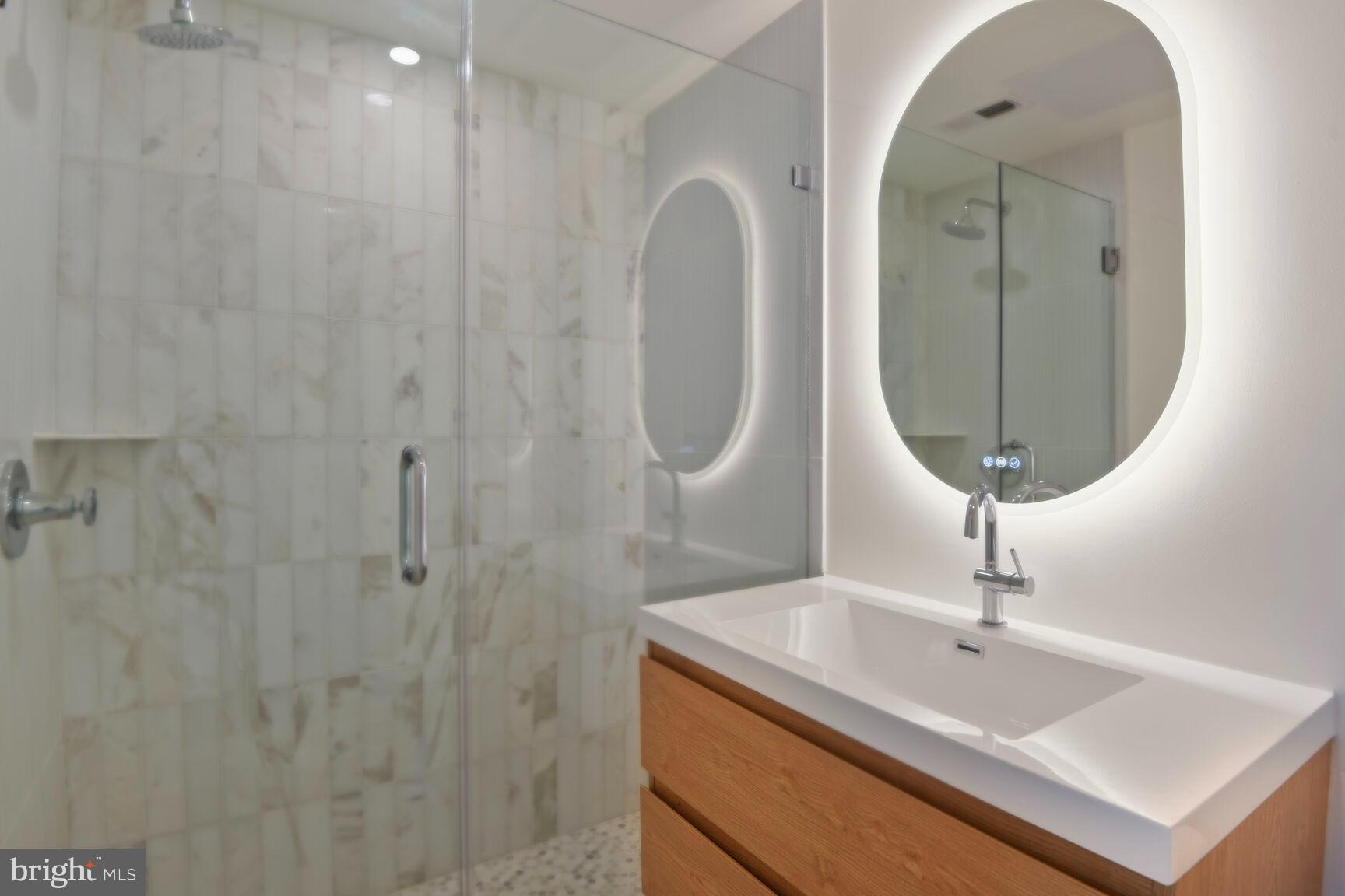 1351 Wisconsin Avenue Northwest, Unit 2B Washington, DC 20007 - Photo 18 of 20 a bathroom with a sink a vanity and a mirror