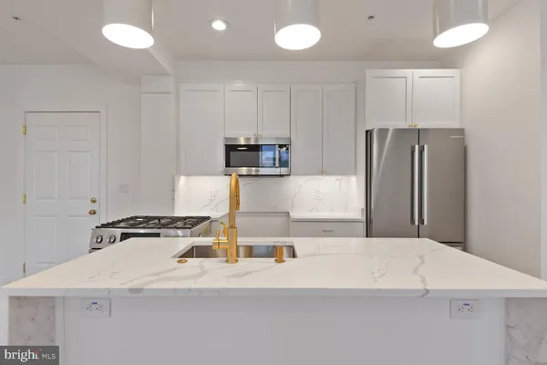 a kitchen with a refrigerator a stove and a sink