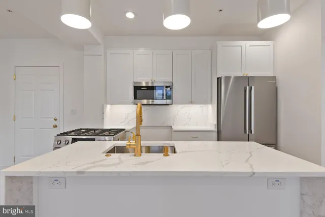 a kitchen with a refrigerator a stove and a sink