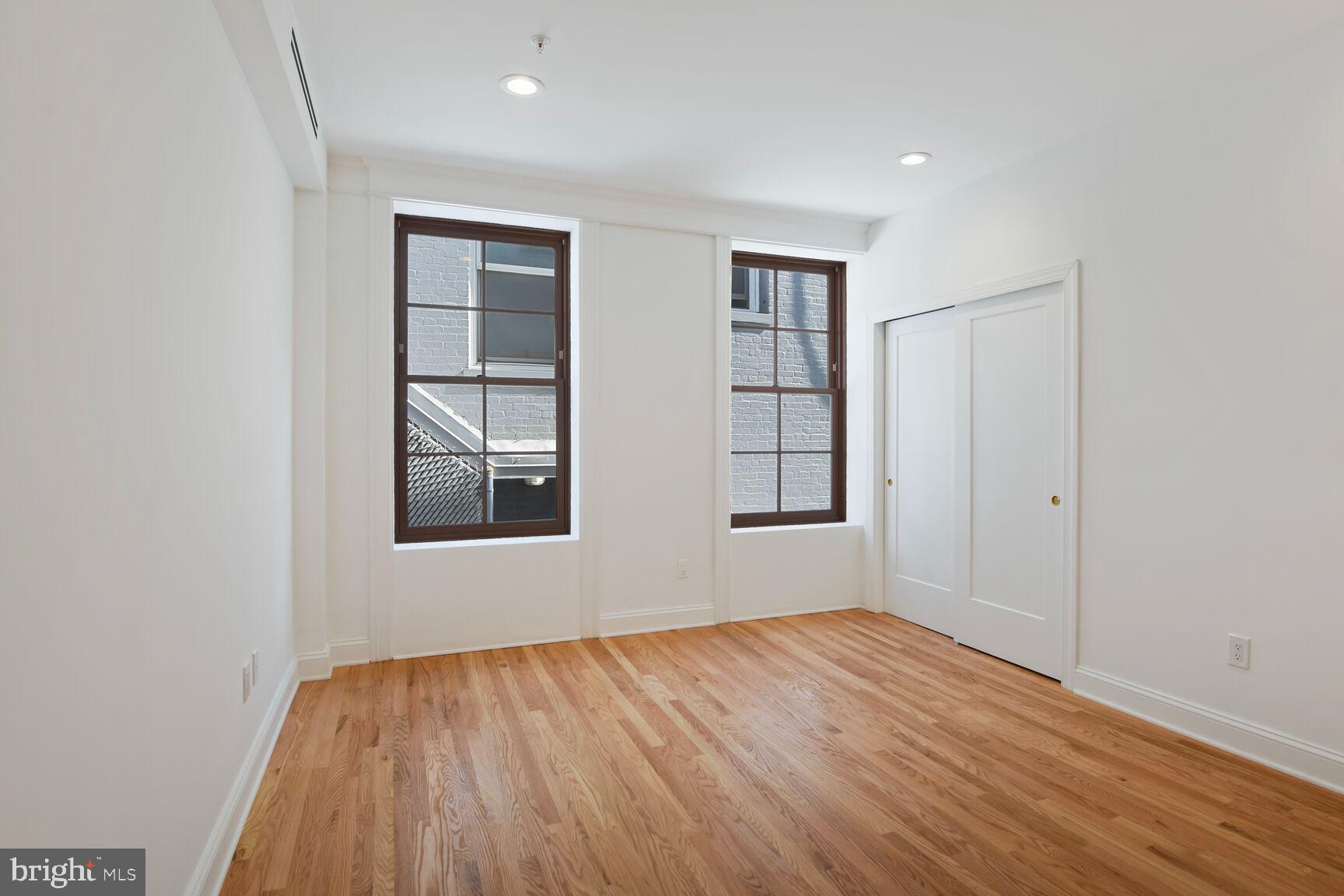 1351 Wisconsin Avenue Northwest, Unit 2B Washington, DC 20007 - Photo 8 of 20 an empty room with wooden floor and windows