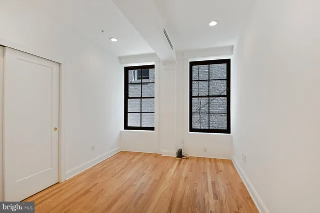 a view of an empty room with wooden floor