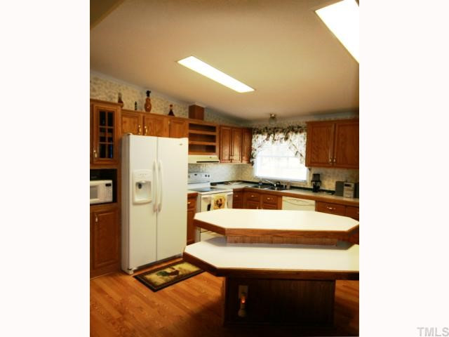 The oversized kitchen offers electric solid surface rang and side-by-side refrigerator w/ice maker. Raised panel cabinets provide beauty and all the storage one could need. The center island is perfect for friends or family to gather around.