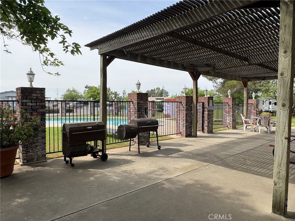 5813 Pacific Heights Road, Unit 126 Oroville, CA 95965 - Photo 57 of 59 a view of a roof deck with table and chairs under an umbrella with a small garden