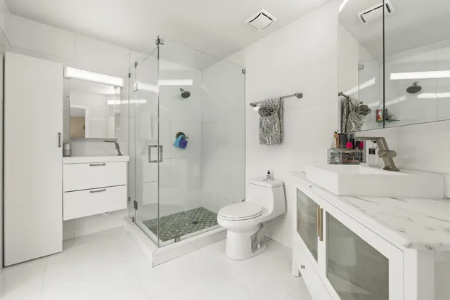a bathroom with a sink a toilet and shower