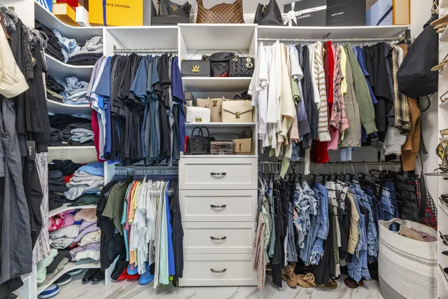 a view of walk in closet with clothes and shoes