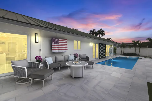 a view of a patio with dining table and chairs with a small yard