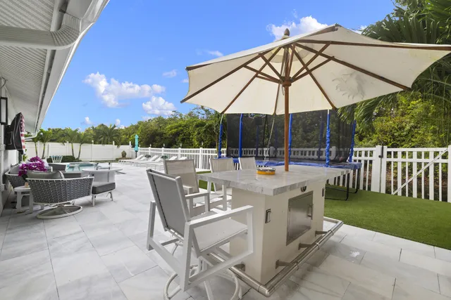 a view of patio with a table and chairs under an umbrella