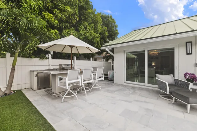 a patio with a table and chairs under an umbrella