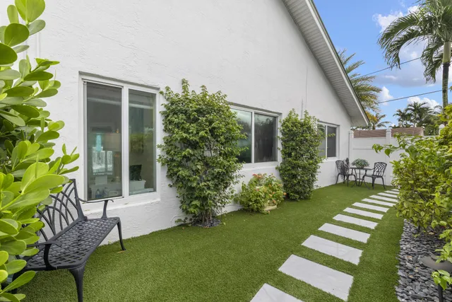 a view of a chair and table in backyard of the house